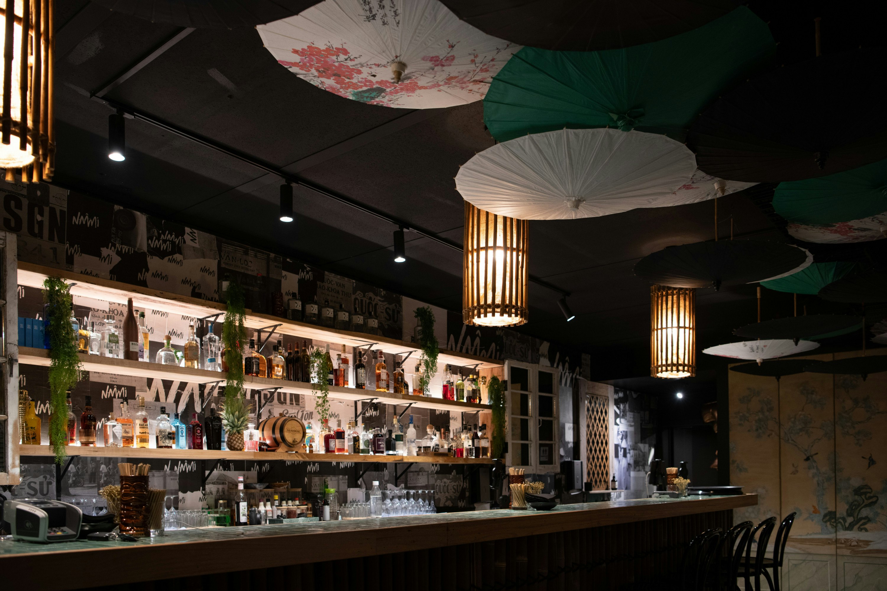 the dark interior of a speakeasy with hanging umbrellas